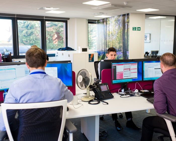 Backs at desks Sam and Andy